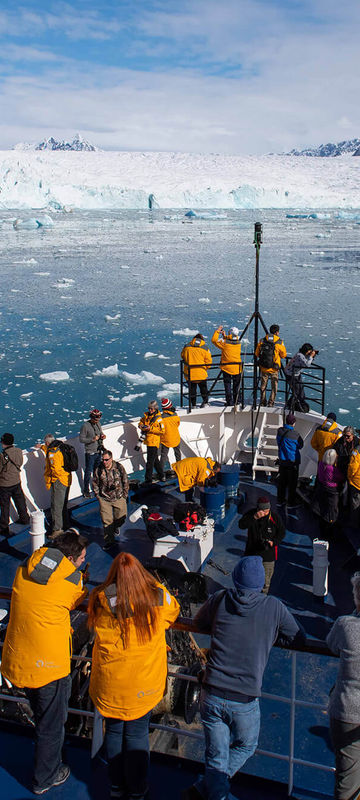 arctic admiring svalbard scenery from ship bow qe