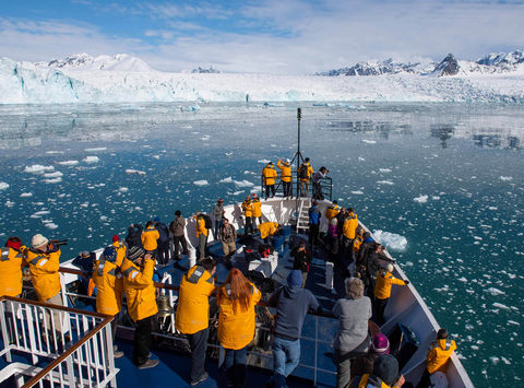 arctic admiring svalbard scenery from ship bow qe