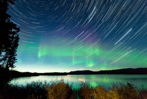 canada yukon northern lights behind star trail whitehorse istk