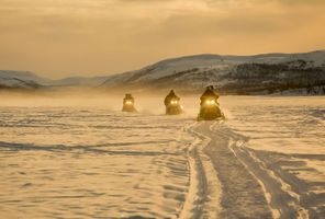 snowmobiling in winter sun istk