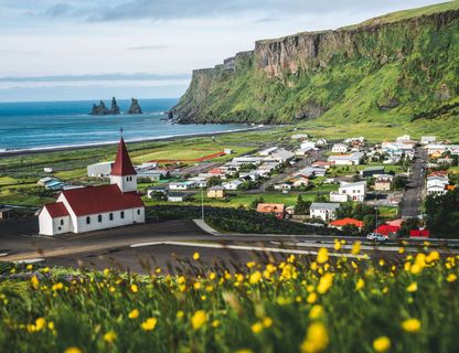 south iceland vik church and reynisdrangar sea stacks sunny day istk