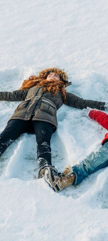 winter fun girls making snow angels istk