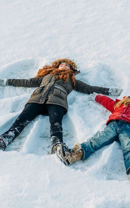 winter fun girls making snow angels istk