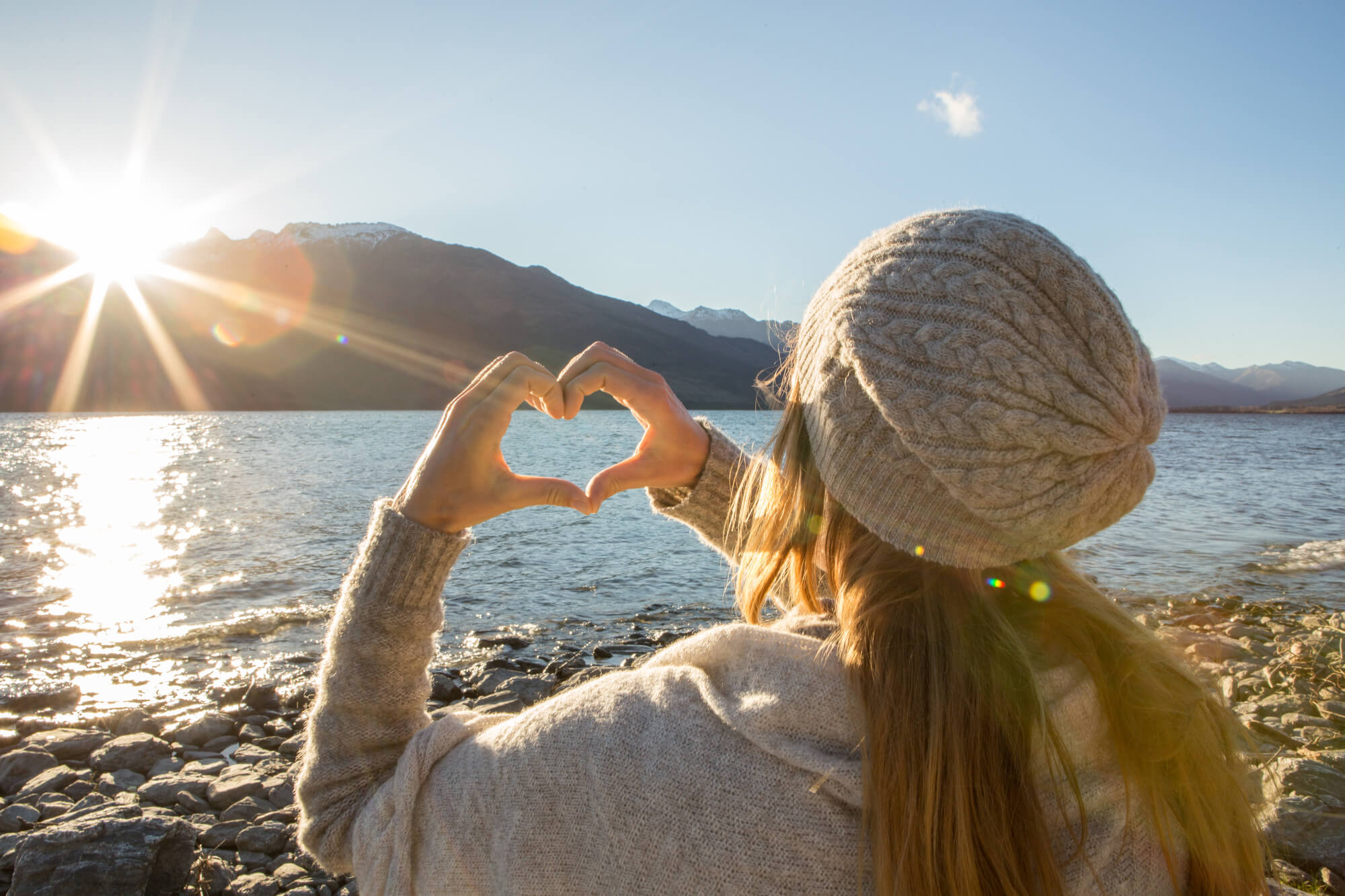 woman-forming-heart-shape-with-hands-sunlight-istk